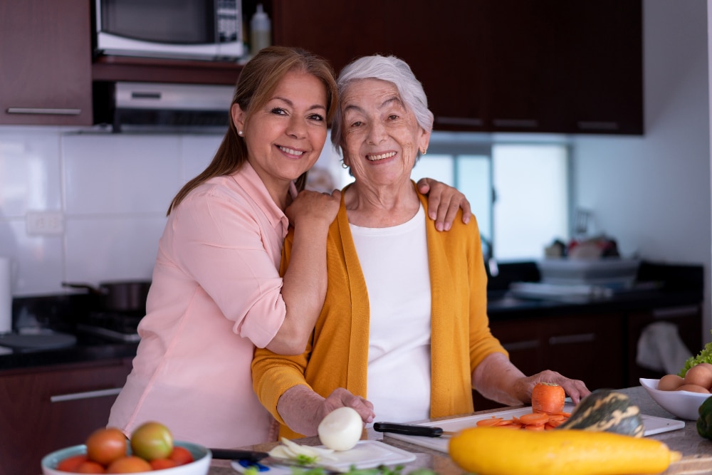 A woman helps her older mother with managing diabetes by preparing a healthy meal with her.