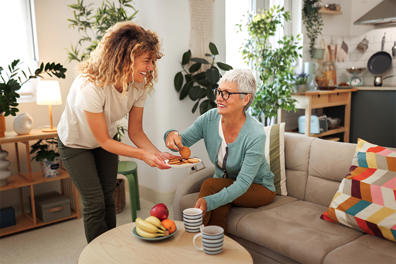 private home care - cargiver serving senior lady in her home