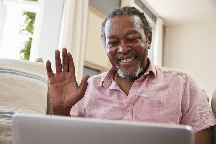 Helping older adults use technology helps them stay socially connected, as this man experiences by using his laptop to chat with a loved one.