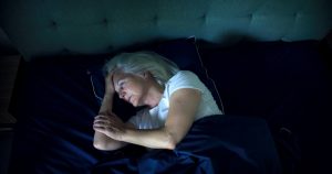 A woman who knows firsthand all about restless nights in older adults stares into space as she tries to fall asleep.